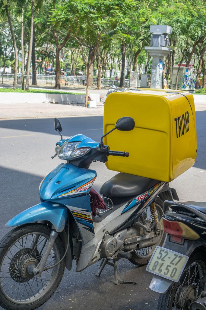 Ein Motorroller mit einer gelben Trump-Kiste in Saigon