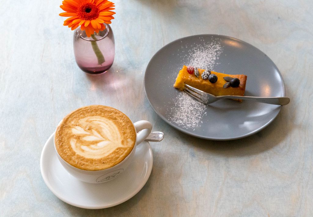Ein Stück Kürbiskuchen mit einer Tasse Cappuccino aus frisch gerösteten Bohnen im Kaffeesaurus in Köln