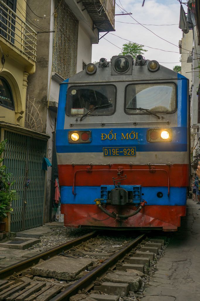 Ein Zug fährt durch eine Enge Gasse in Hanoi, Vietnam