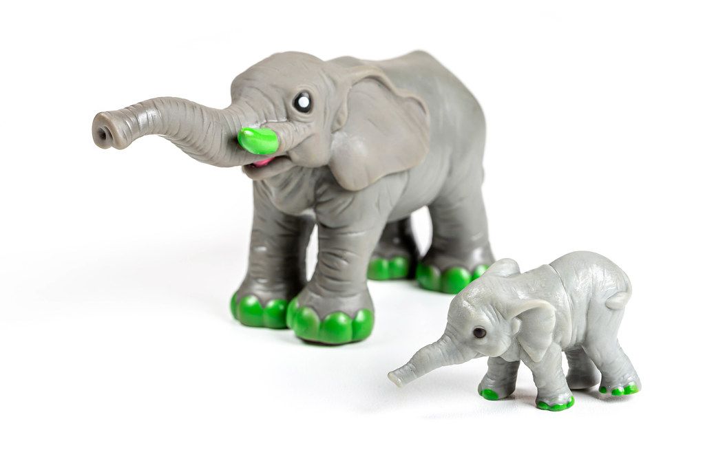 Elephant and baby elephant figures on a white background
