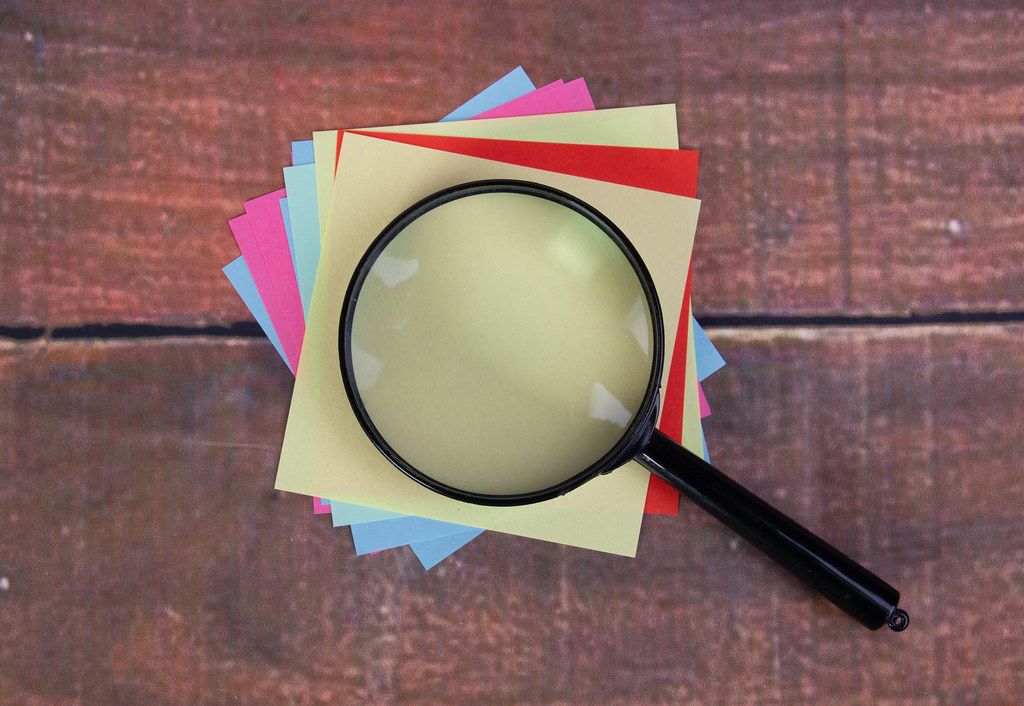 Empty colorful sticky notes with magnifying glass