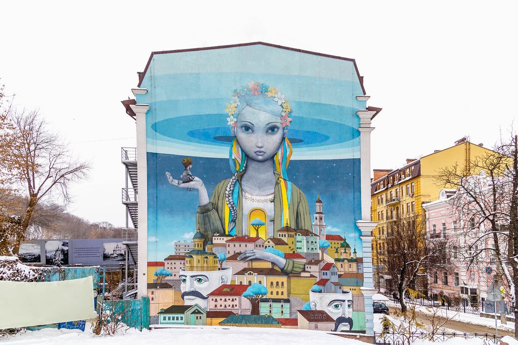 Fantasievolle Straßenkunst Mädchen und Häuser auf Gebäude vor urbanem Hintergrund