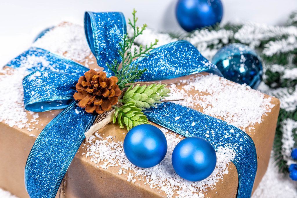 Festive gift with blue ribbon and christmas tree balls
