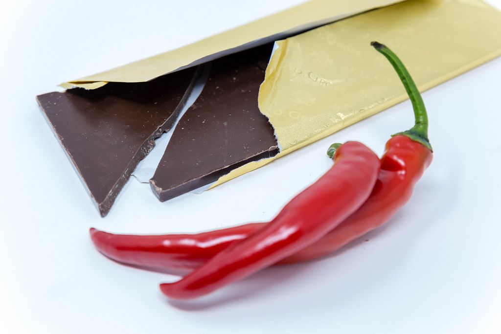 Fine dark chocolate in gold packaging with two red peppers