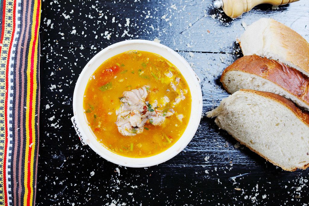 Fish soup served with homemade bread, black background (Flip 2019)