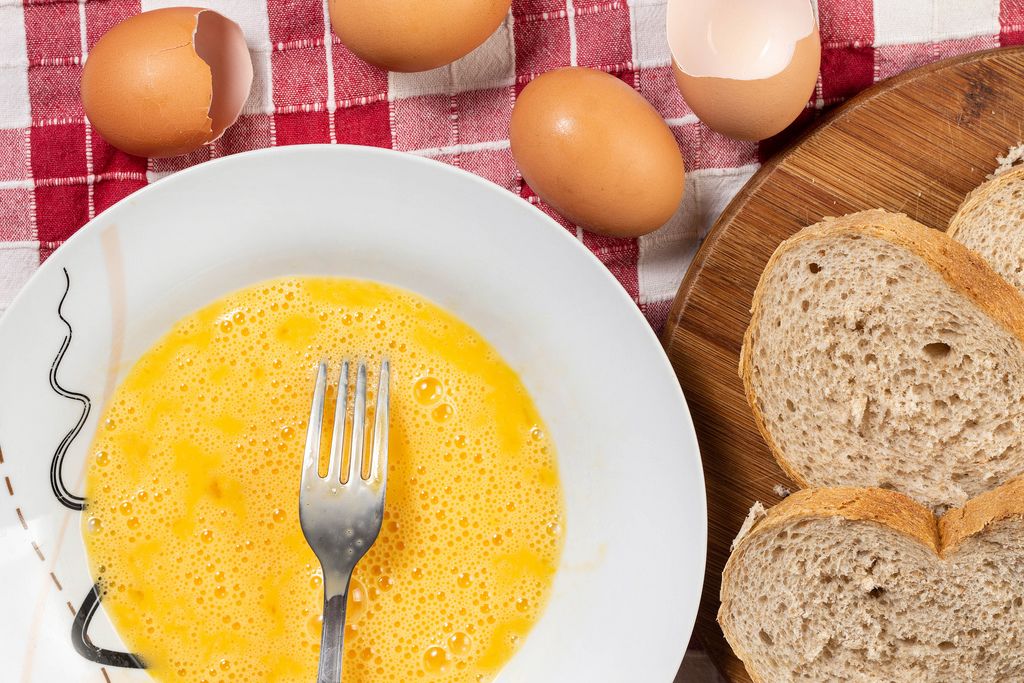 Flat lay above Eggs in the plate and Bread slices