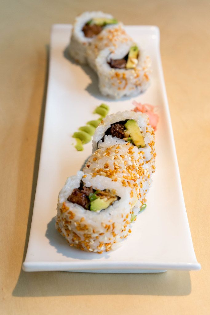Fleischloses Sushi als japanisches, veganes Mittagessen mit gebackenem Tofu, Avocado, Röstzwiebeln, veganer Mayo und Kimchi-Sesam