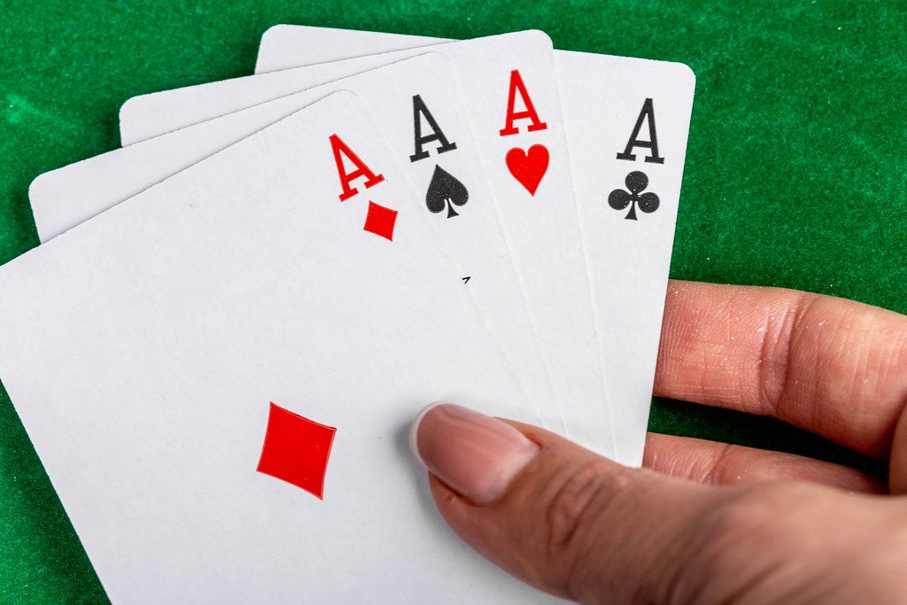 Four aces in a woman's hand on a green background. Playing cards concept (Flip 2019)