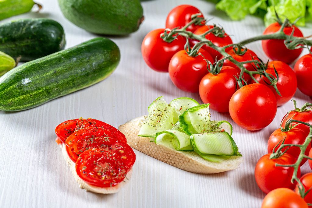 Fresh vegetables and sandwiches with sliced tomatoes and cucumbers