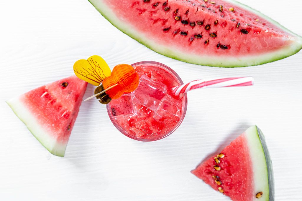 Fresh watermelon smoothie in the glass on wooden white background. Summer, healthy organic food concept.