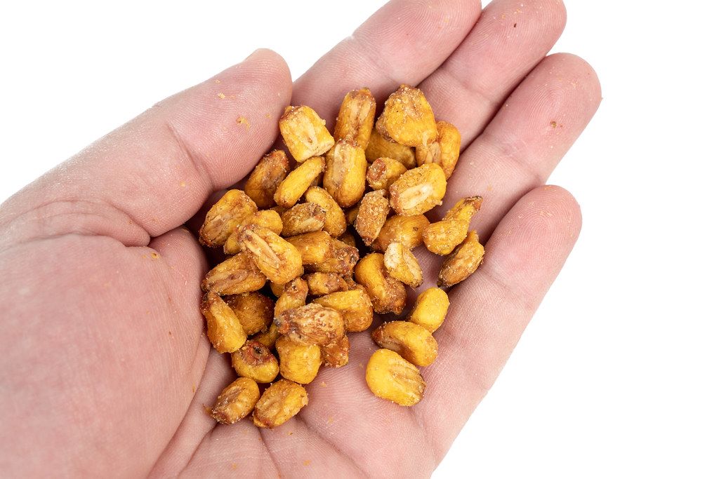 Fried Corn in the hand above white background