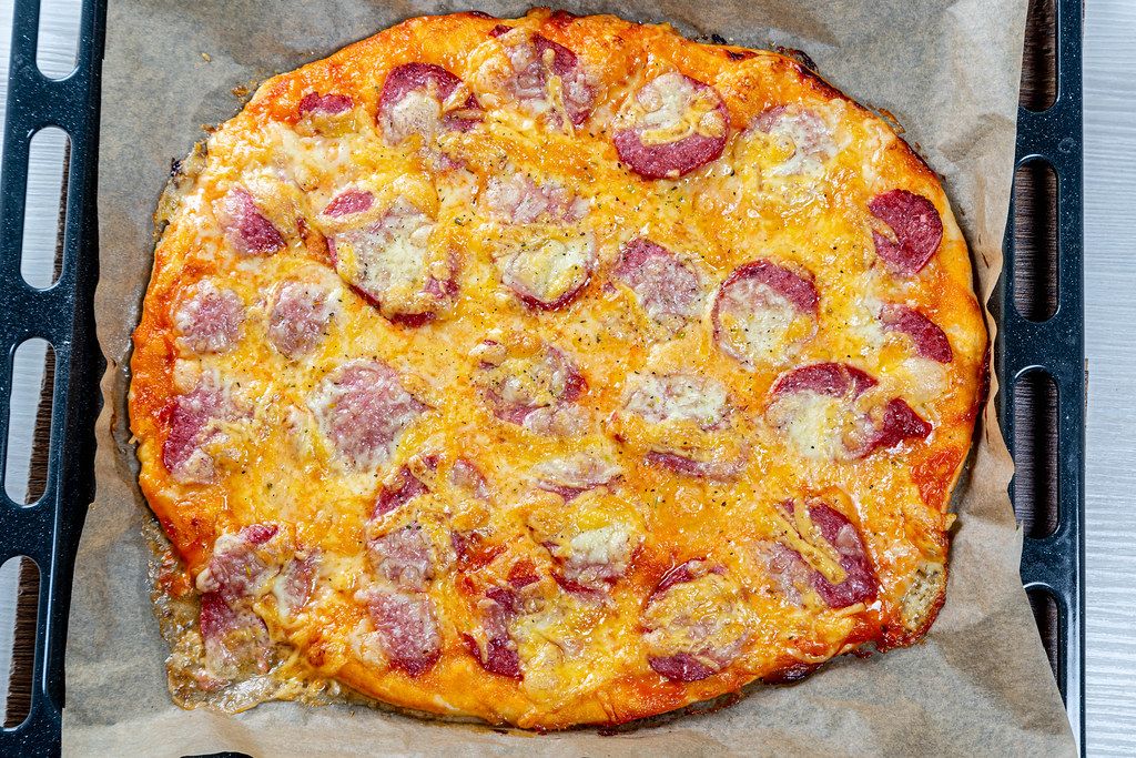 Frisch gebackene hausgemachte Pizza mit Wurst und Käse auf einem ...