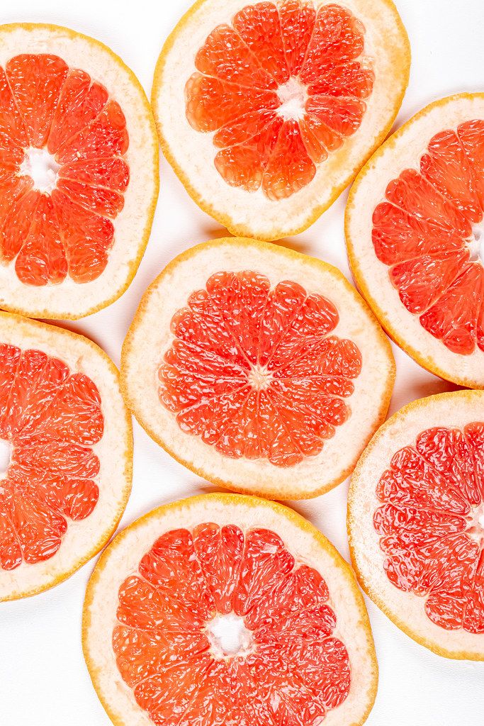 Frische Grapefruitscheiben vor weißem Hintergrund in obene Aufnahme