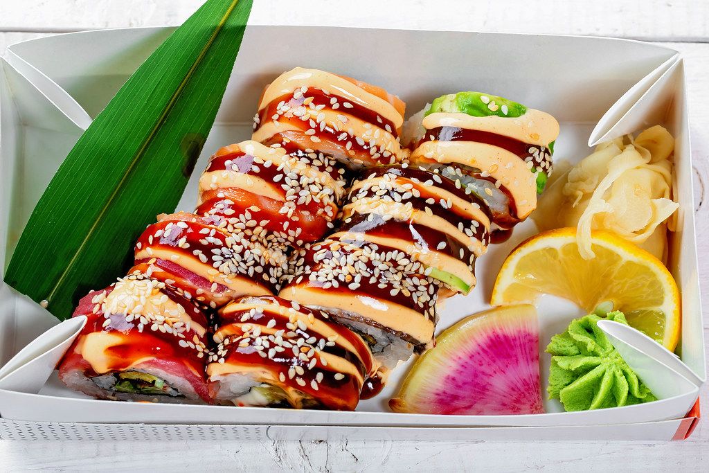 Frischen Sushibox mit Rainbow-Dragon-Sushi, eingelegt mit Ingwer und Wasabi