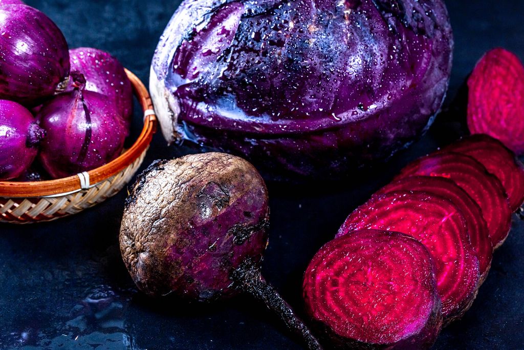 Frisches purpurrotes Gemüse auf dunklem Hintergrund
