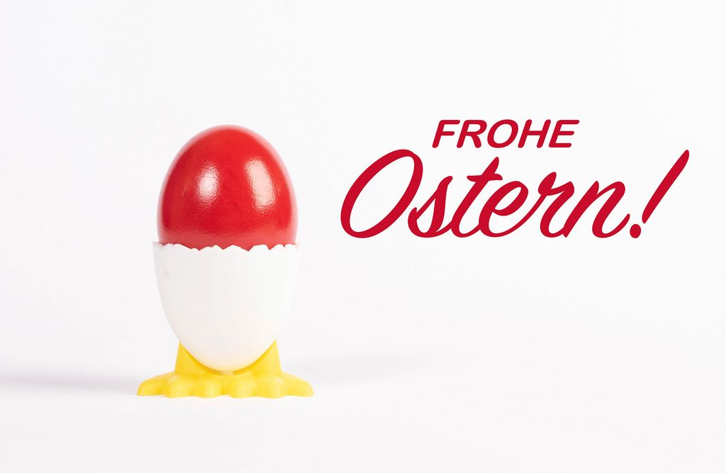 Frohe Ostern text with red painted Easter egg