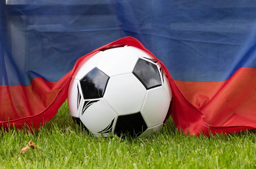 Fußball auf dem Rasen bedeckt mit russischer Flagge