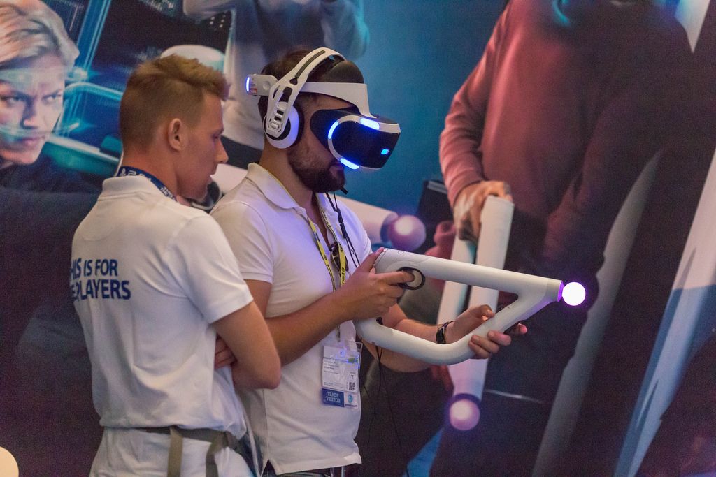 Gamer with PlayStation VR Headset and Aim Controller at Gamescom