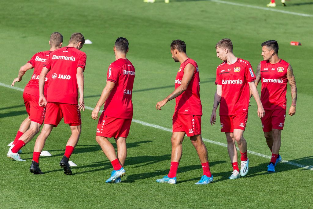 Three soccer players Lucas Alario, Wendell and Kai Havertz leaving the pitch happy and barefoot ...