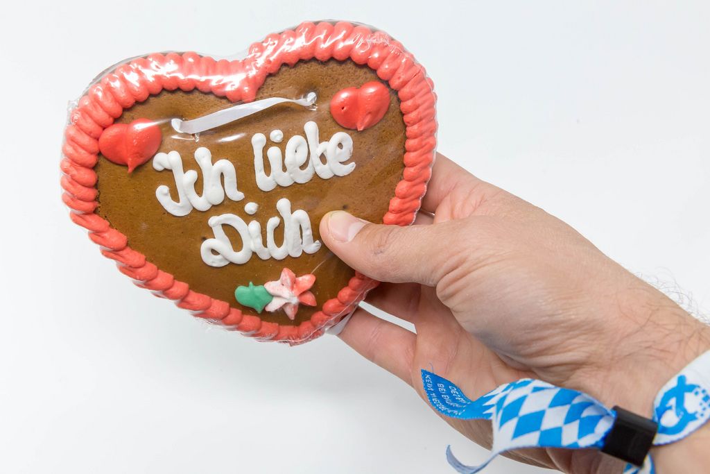 Gingerbread heart from the Oktoberfest with the writing - Ich Liebe Dich - held in hand