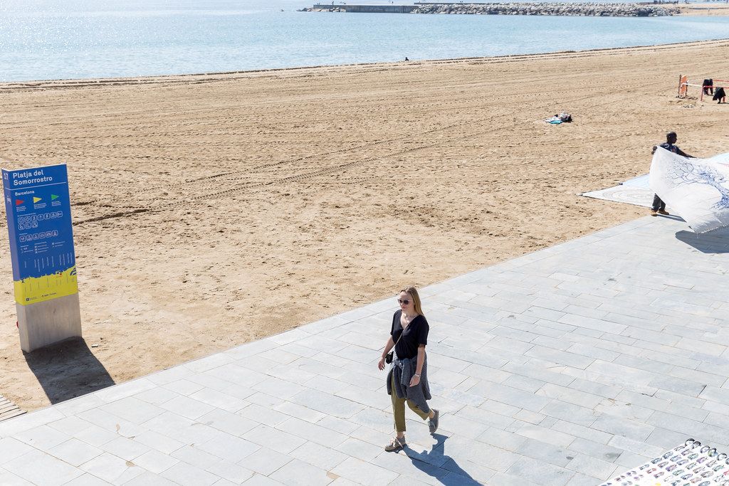 Girl in sunglasses walks at Platja del Somorrostro beach in Barcelona