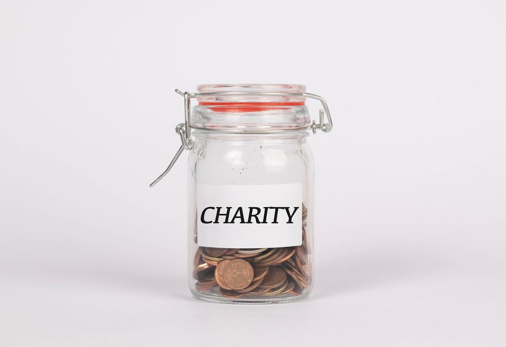 Glas gefüllt mit Münzen mit Beschriftung CHARITY symbolisiert Geld sammeln für wohltätige Zwecke
