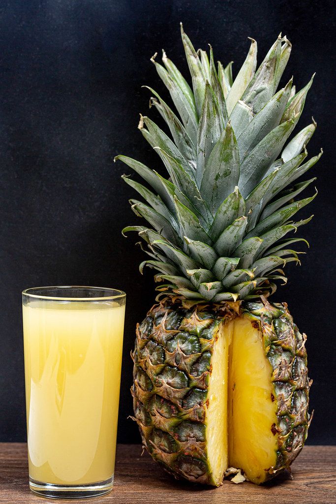 Glass of fresh pineapple juice with ripe pineapple