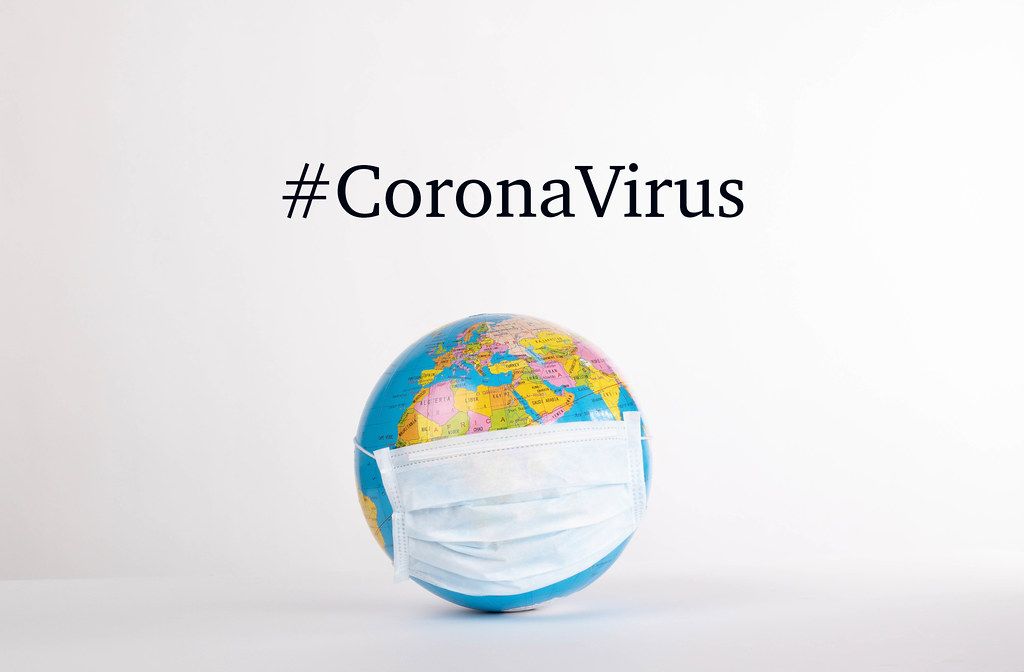 Globe with medical mask and #CoronaVirus text on white background