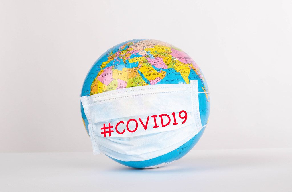 Globe with medical mask on white background with #COVID19 text