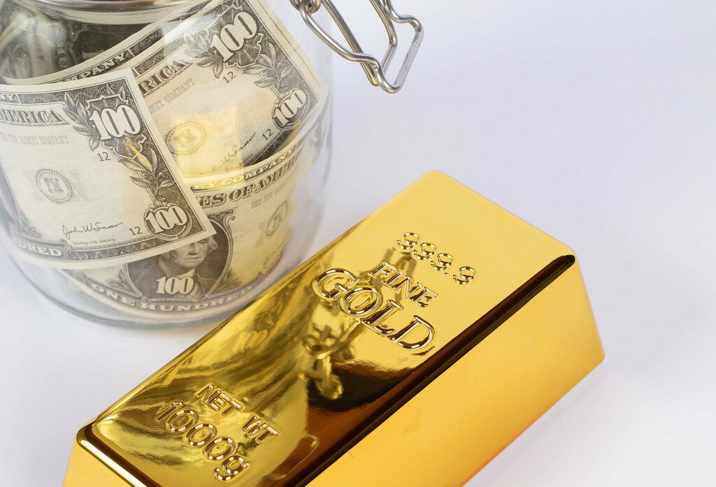 Gold bar with glass jar full of money