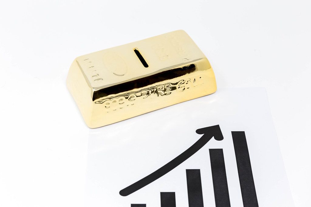 Gold bars with graph of diagram and arrow symbolizes rise of gold price