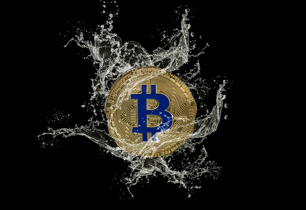 Golden Bitcoin and water splash on dark background