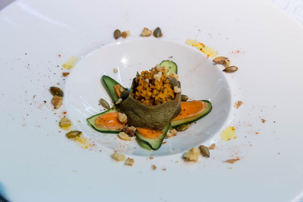 Gourmet-Speise Pasteten mit Gurke und Karotte angerichtet in Form einer Blume auf weißem Teller