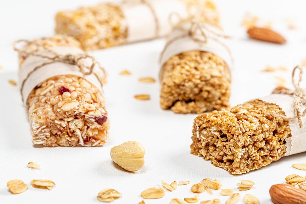 Granola bars with oat flakes, dried fruits and seeds on a white background