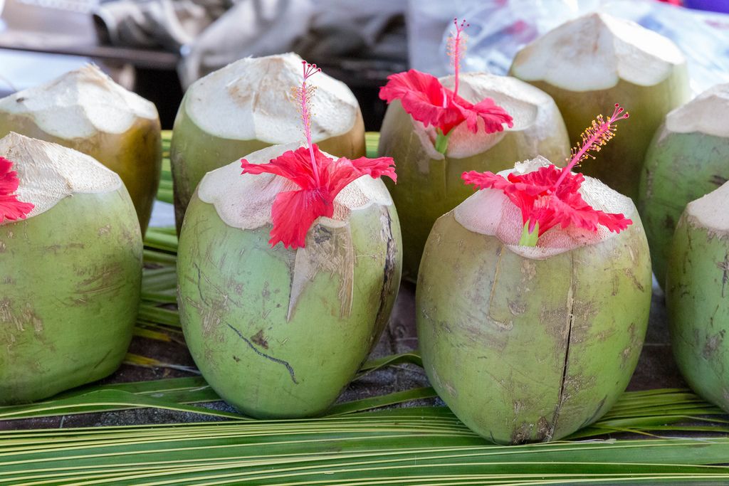 Green coconuts on palm leaves decorated with red amaryllis flowers at a Beach Bar of Anse Source d'Argent in La Digue, Seychelles Island