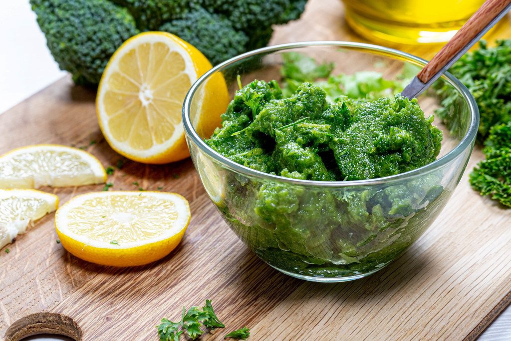 Green sauce with fresh herbs with vegetables in a glass bowl closeup. The concept of healthy eating
