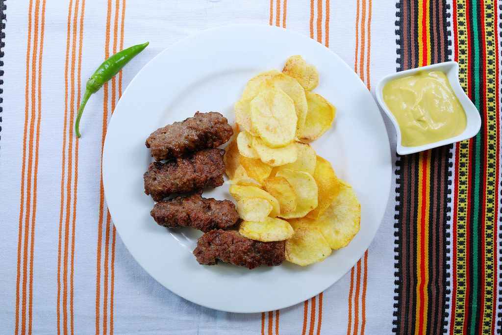 Grilled minced meat rolls with fried potatoes and mustard
