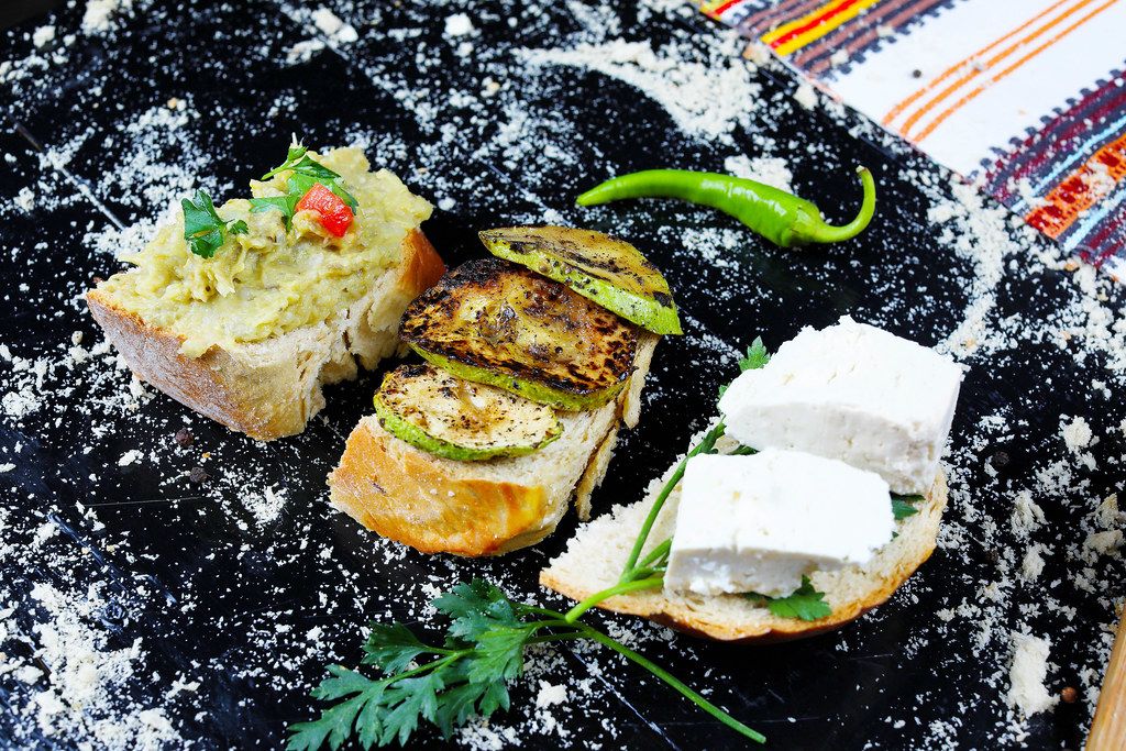 Grilled zucchini slices, eggplant salad and cheese sandwiches on black background (Flip 2019)