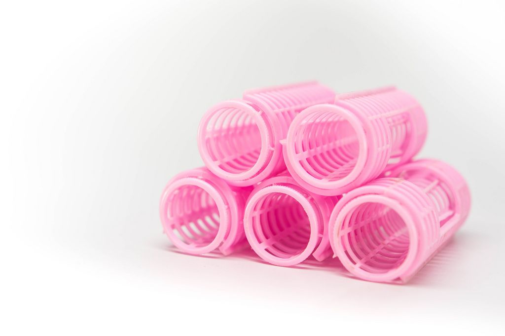 Group of plastic curler tubes on a white surface