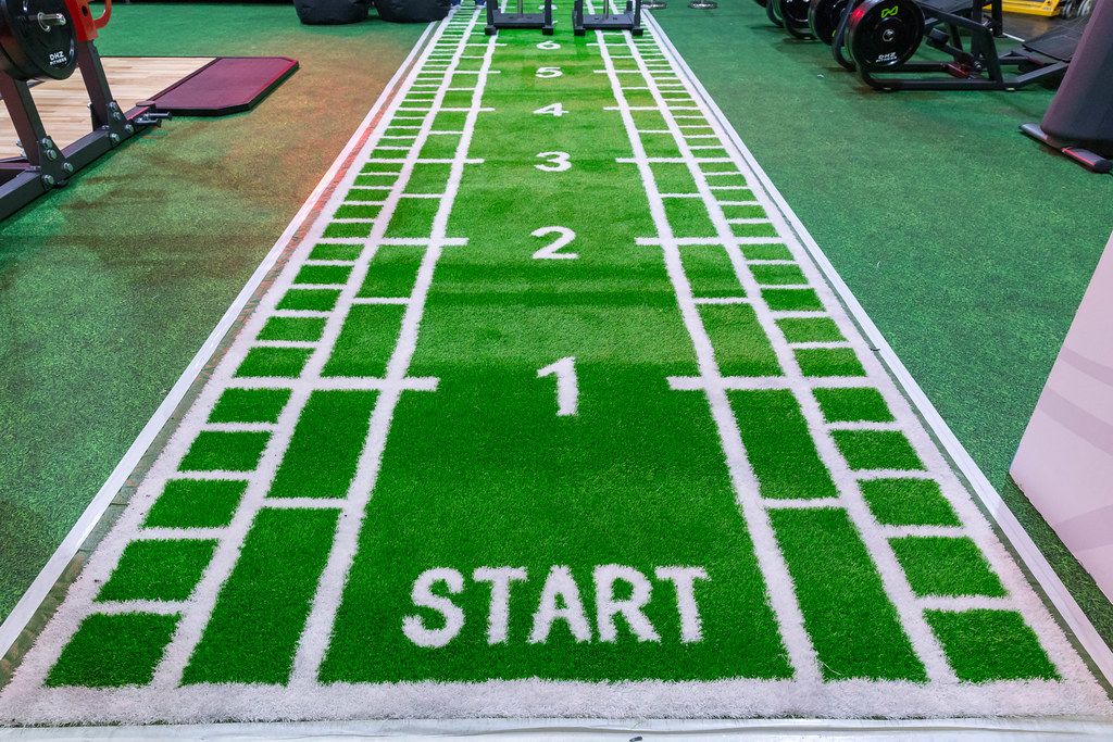 Grüner Fitness-Teppich mit Start-Zeichen und Zahlen in einem Probe-Fitnessraum auf dem Fibo-Messe Köln
