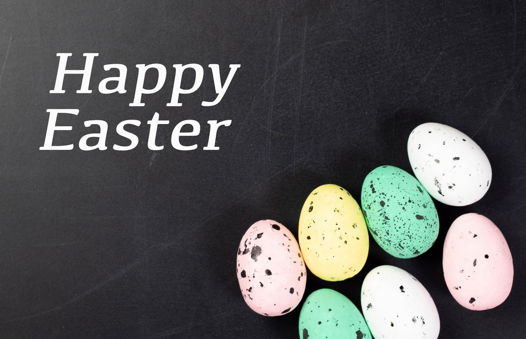 Grußkarte mit Text HAPPY EASTER (frohe Ostern) mit eingefärbten Ostereiern vor dunklem Hintergrund