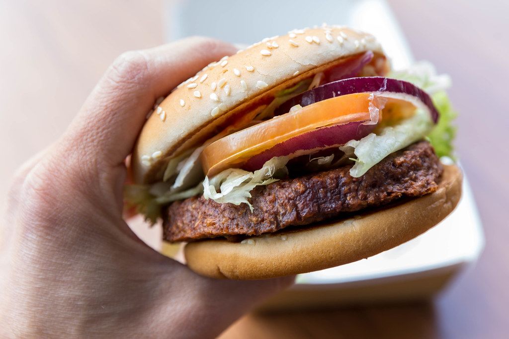 Hand hält in der Nahaufnahme den veganen McDonalds Burger 