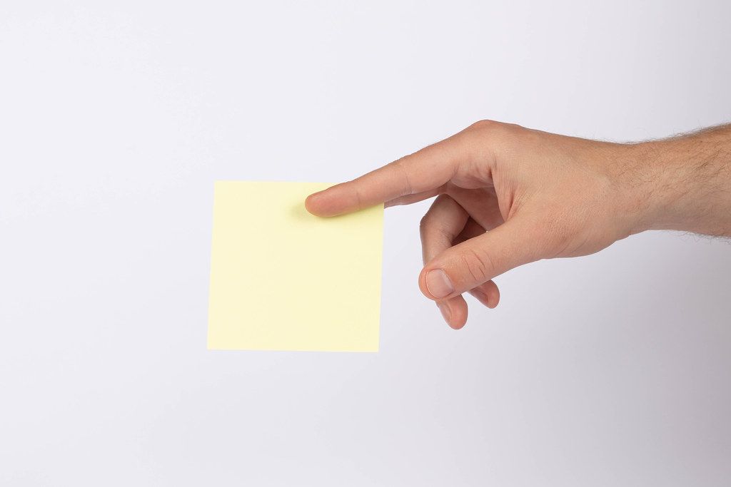 Hand holding empty yellow paper (Flip 2019)