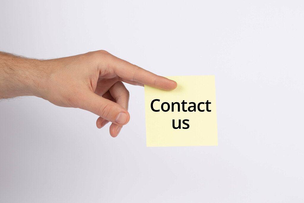 Hand holding note with Contact us text