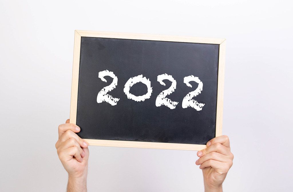 Hands holding blackboard with 2022 text
