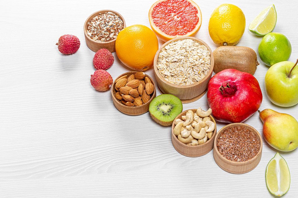 Healthy food ingredients. Fruits, nuts, seeds on wooden white background