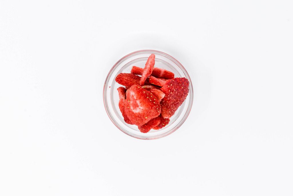 High Angle Shot - Lio Bites - dried organic Strawberries in glas bowl on white background