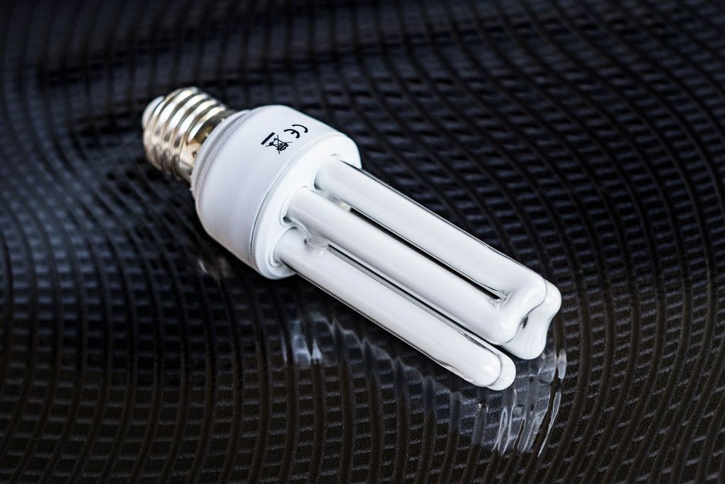 High Angle View of  the Compact Fluorescent Light Bulb on the Black Table