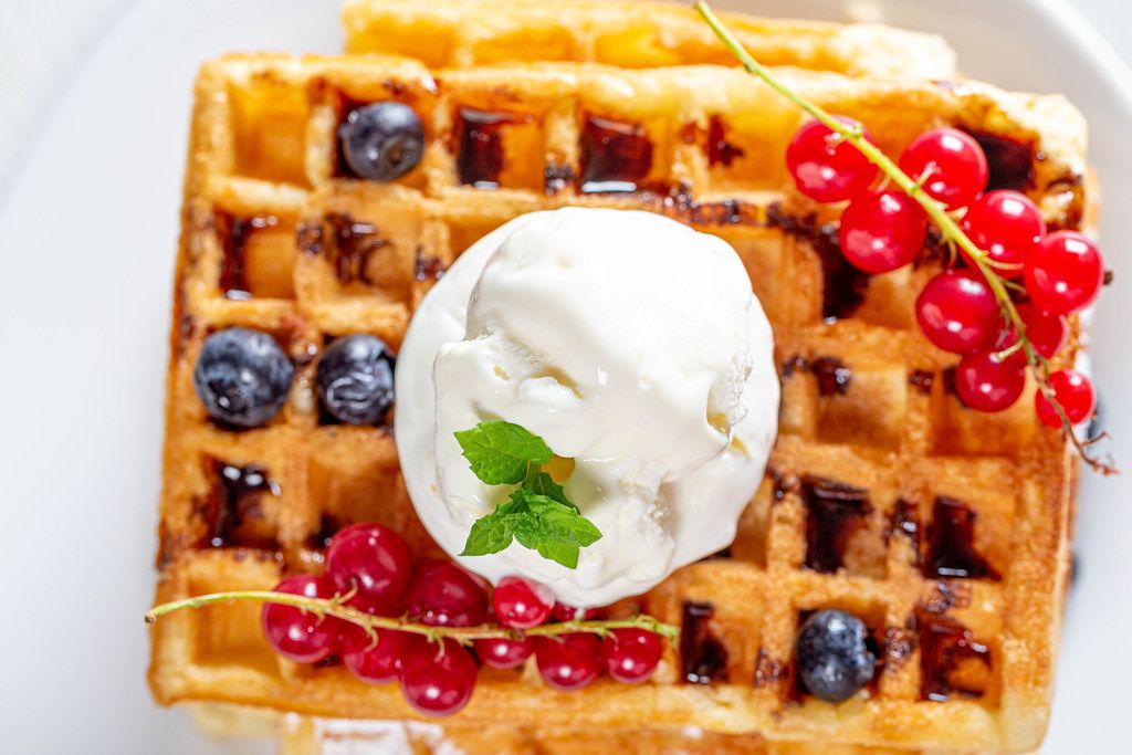 Ice cream with mint leaves and fresh berries on Belgian waffles (Flip 2019)