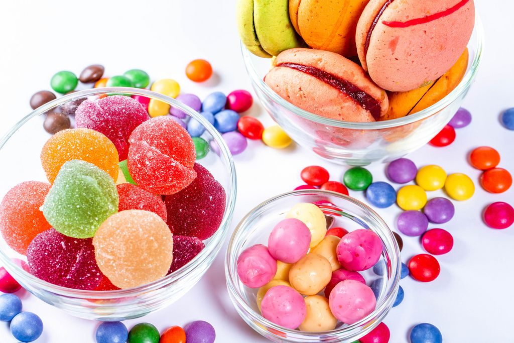 In Glasschüsseln Gummibärchen und Marmelade farbige Süßigkeiten